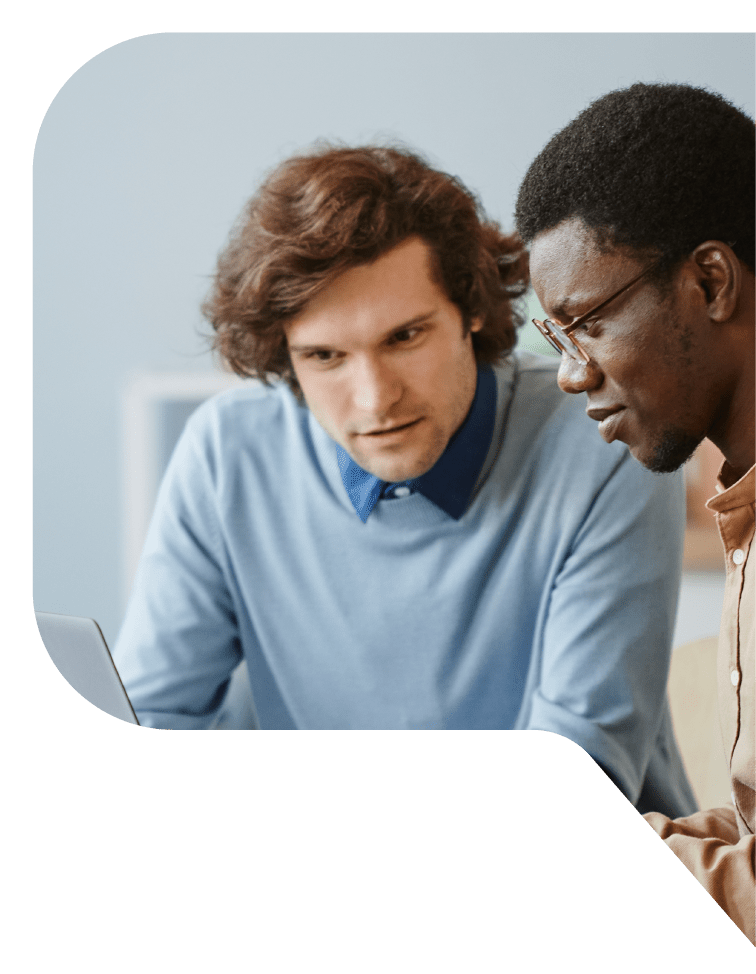 Two men look intently at a laptop.